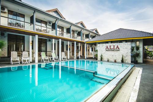 a hotel swimming pool in front of a building at Alia Residence Business Resort in Kampung Padang Masirat