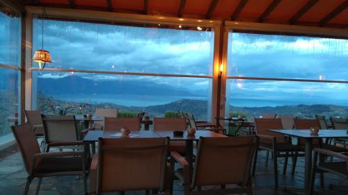 a restaurant with tables and chairs and a large window at Gerofotis Traditional Guesthouse est 1892 - Close to Aigio, Akoli, Selianitika in Lákka