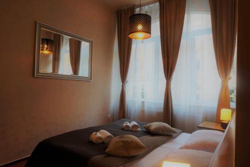 a bedroom with a bed with two slippers on it at Augustus et Otto Hotel in Prague