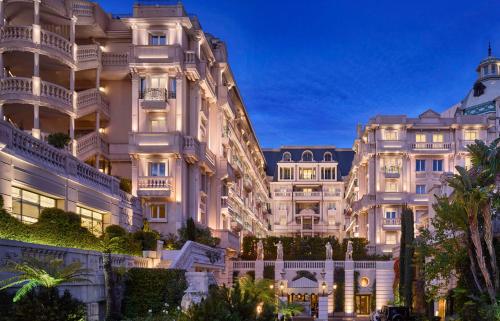 a view of a large white building at night at H&ocirc;tel M&eacute;tropole Monte-Carlo - The Leading Hotels of the World in Monte Carlo