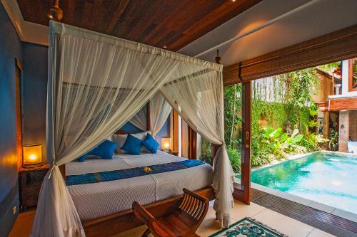 a bedroom with a bed and a swimming pool at Umah Watu Villas in Seminyak
