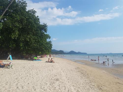 um grupo de pessoas sentadas numa praia em 15 Palms Beach Resort em Ko Chang