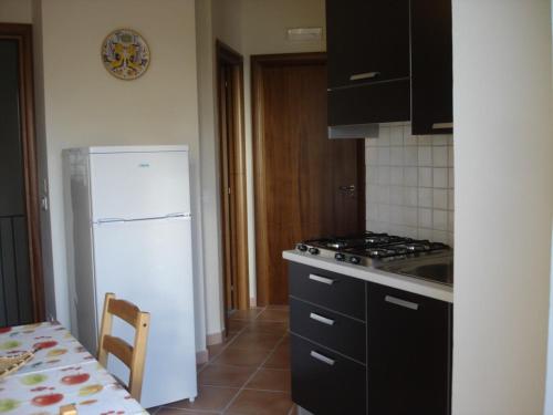 a kitchen with a stove and a white refrigerator at Casa Le Querce in Ogliastro Cilento
