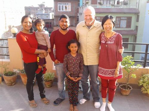 a family posing for a picture on a balcony at Shine Homestay Famille Francophone - Shine Home and Apartment in Kathmandu