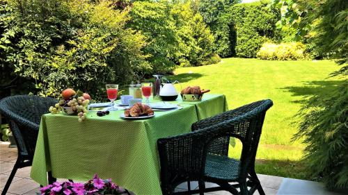 zielony stół z jedzeniem i napojami w obiekcie La Collina since 2008 NO SMOKING B&B w mieście Varese