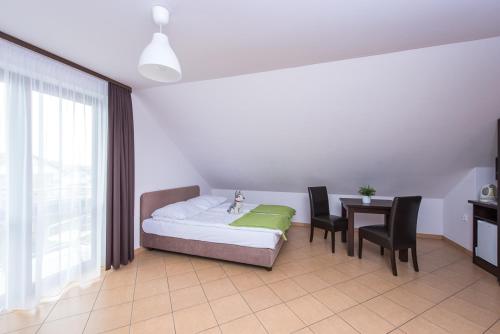 a bedroom with a bed and a table and chairs at Willa Północna in Karwia