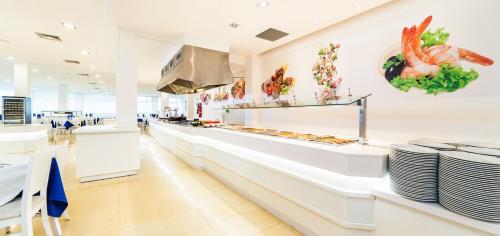une ligne de buffet dans un restaurant avec des assiettes dans l'établissement Globales Samoa, à Calas de Mallorca