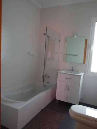 a bathroom with a bath tub and a sink at Paraiso das Flores in Estreito da Calheta