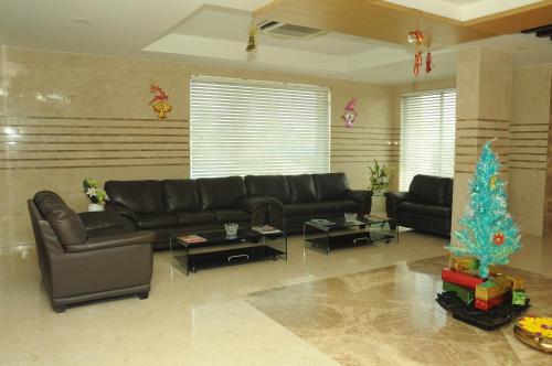 a living room with a couch and a christmas tree at Ponnis Grand Inn in Chennai