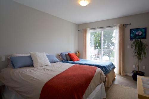 a bedroom with a bed and a window at Halfmoon Haven Beach Cottage or Oceanview Suite in Halfmoon Bay