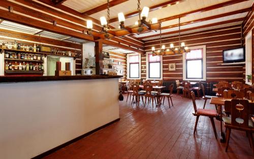 a restaurant with a bar and tables and chairs at Penzion Varšavjanka in Harrachov