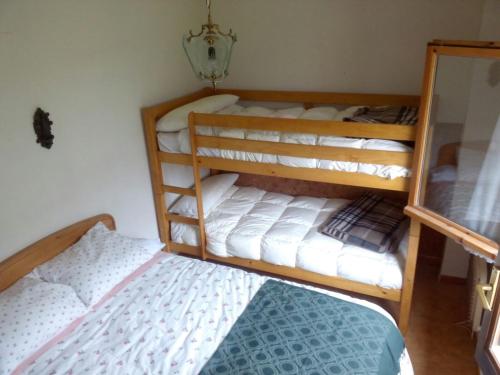 a bedroom with two bunk beds and a bed at Apartamento MODESTO en las montañas del pirineo aragonés en Alquiler Altruista ECONÓMICO in Villanúa