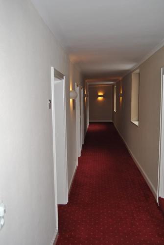 a long hallway with a red carpet and white walls at Lodner Hotel Drei Mohren in Lauingen