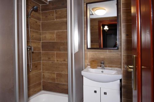 uma casa de banho com um lavatório e um chuveiro em Hotel Kuria em Banská Bystrica