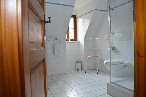 bagno bianco con doccia e servizi igienici di Theophano´s Appartements im Kornmarkt a Quedlinburg