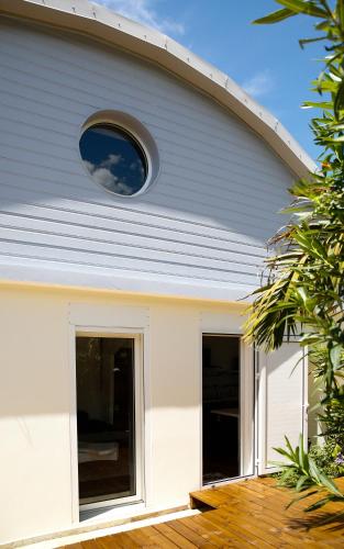 a white house with a window on the side of it at Nolitha in Manapany-les Bains