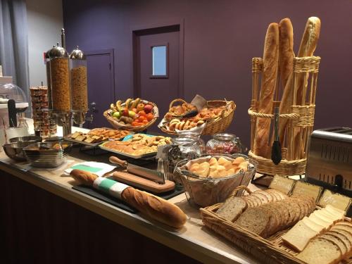a table topped with lots of bread and baskets of food at Hotel du Casino in Saint-Valéry-en-Caux