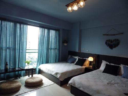une chambre avec deux lits et une grande fenêtre dans l'établissement Woods Decor - Anping, à Tainan