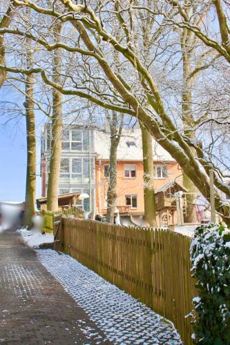 a fence in front of a house with snow on the ground at Appartment Döllinger Messe Fränkisches Seenland in Schwabach
