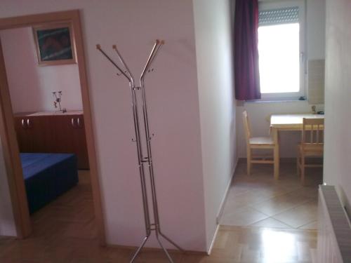 ein Wohnzimmer mit einer weißen Wand und einem Tisch in der Unterkunft Arena Jaruščica Apartment in Zagreb