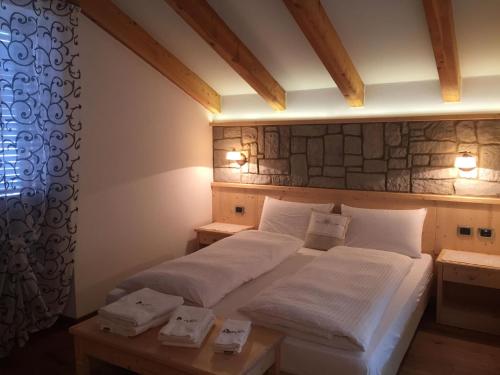 a bedroom with a bed with white sheets and pillows at Affittacamere Dolce Sogno in Coredo