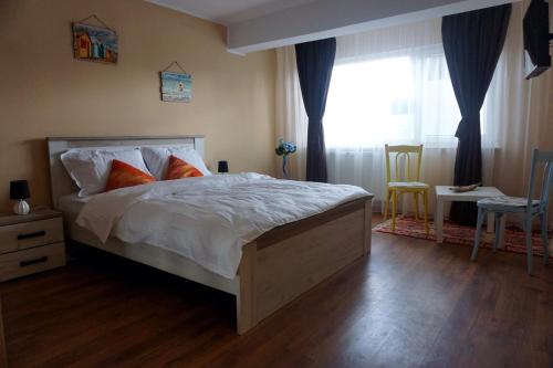 a bedroom with a large bed and a window at Seafront Faleza Nord in Constanţa