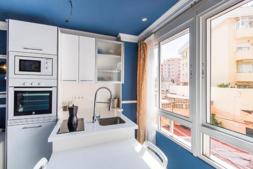 a kitchen with blue walls and a large window at Luxury Torremolinos in Torremolinos