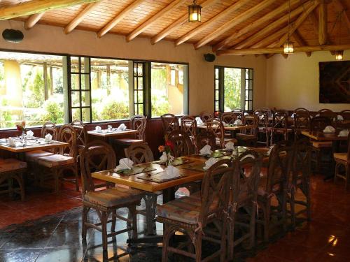 a dining room with tables and chairs and windows at Termas de Papallacta in Papallacta