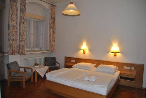 a bedroom with a bed and a table and chairs at Lodner Hotel Drei Mohren in Lauingen