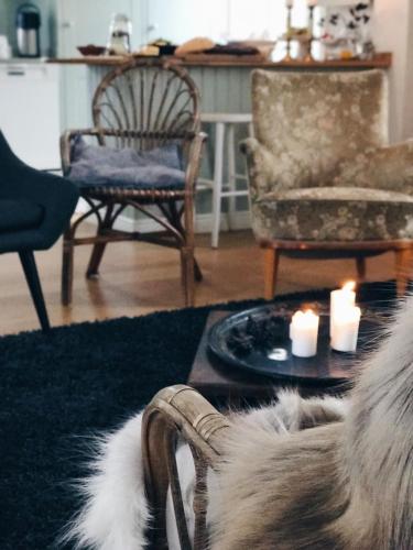 a living room with a pair of shoes and candles at Pensionatet in Piteå