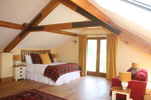 a bedroom with a bed and a couch in a attic at The Byre in Keswick