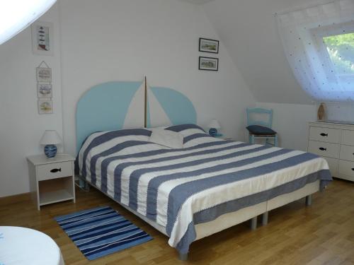 a bedroom with a bed with a blue and white striped blanket at Chambres d'hôtes de Penn Ar Yeun in Landrévarzec