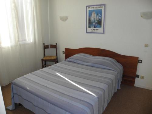 a bedroom with a bed and a chair in it at Le Barry in Villefranche-dʼAlbigeois