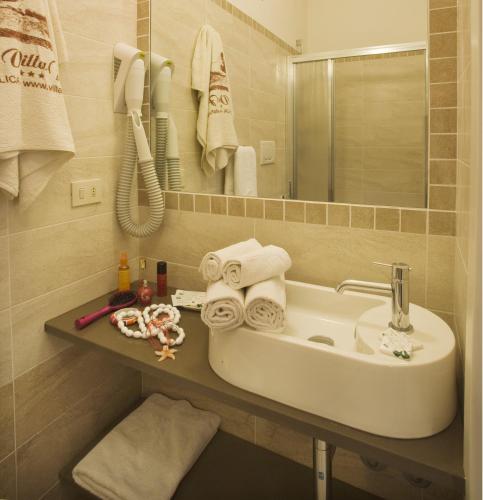 a bathroom with a sink and a telephone and towels at Hotel Villa Fulgida in Cattolica