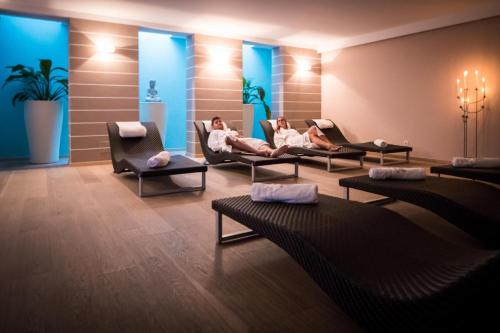 two people sitting in chairs in a waiting room at Hotel Weingarten in Appiano sulla Strada del Vino