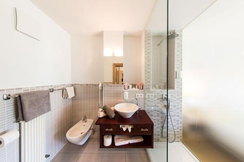 a bathroom with a sink and a bath tub at Hotel Weingarten in Appiano sulla Strada del Vino