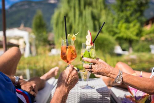a group of people sitting at a table with drinks at Hotel Weingarten in Appiano sulla Strada del Vino