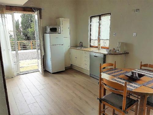 d'une cuisine avec une table, un réfrigérateur, une table et une fenêtre. dans l'établissement Douceur de Vignes, à Servian