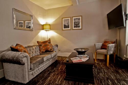 a living room with a couch and a table at The Saracens Head Hotel - The Coaching Inn Group in Great Dunmow