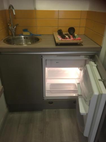 an open refrigerator in a kitchen with a sink at Lincoln Self Catering in Lincoln