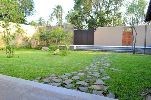 a dog walking in the grass in a yard at Kethaka Aga in Tissamaharama