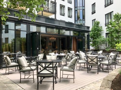 a patio with tables and chairs in front of a building at Hotel München Palace in Munich