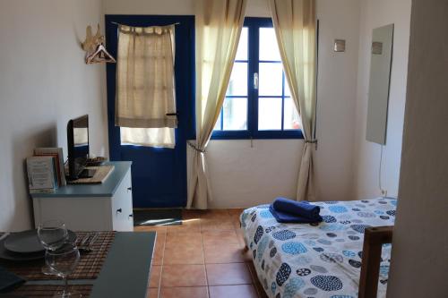 1 dormitorio con cama, escritorio y ventana en Casita del Rio 2, en Caleta de Sebo