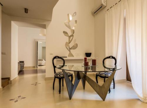 a dining room with a glass table and two chairs at etnart gallery house in Catania