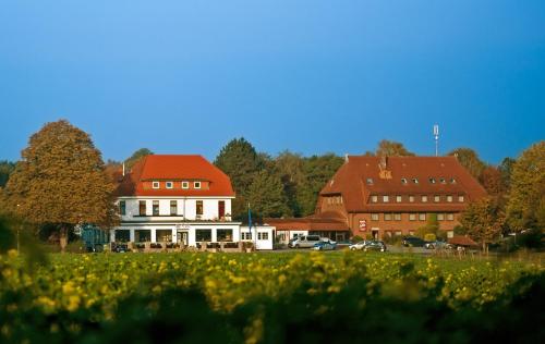a large white house with a red roof at Akzent Hotel Cordes & Restaurant am Rosengarten in Sottorf