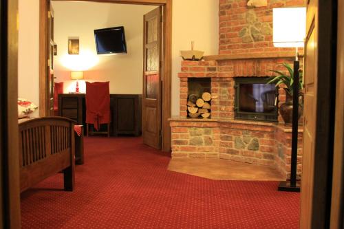 a living room with a brick fireplace in a room at Hotel Polak in Zamość