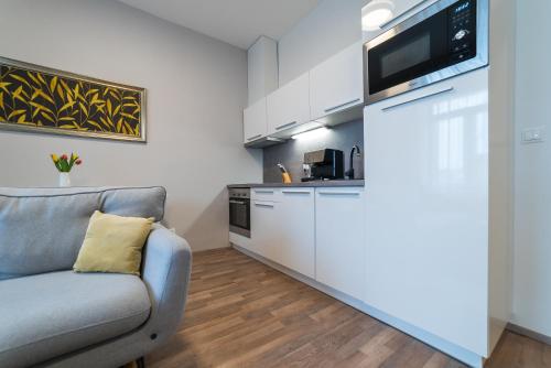 a living room with a couch and a kitchen at MyApartment in the city center in České Budějovice