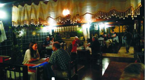 a group of people sitting at tables in a restaurant at Akay Hotel in Patara