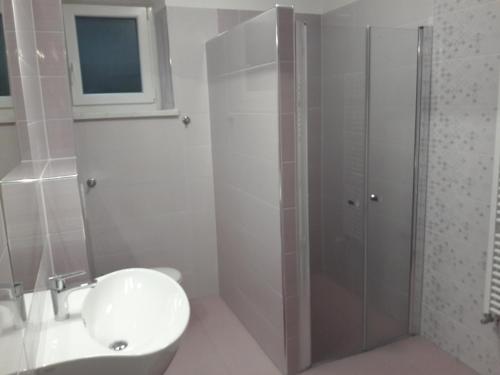 a bathroom with a shower and a toilet and a sink at Apartments and Rooms Knez in Portorož