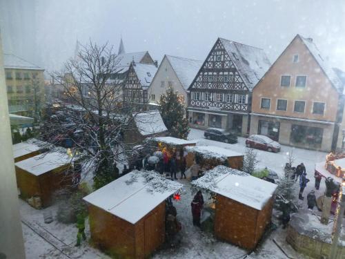 a group of people standing around a christmas market in the snow at Resengörg in Ebermannstadt
